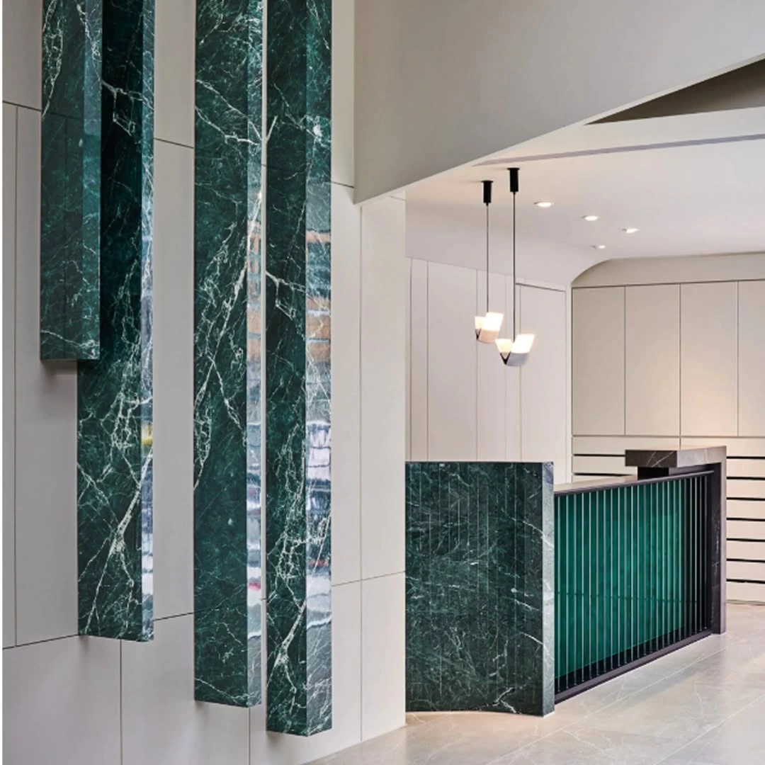 Verde Roccia mermerle tasarlanmış modern bir resepsiyon alanı.